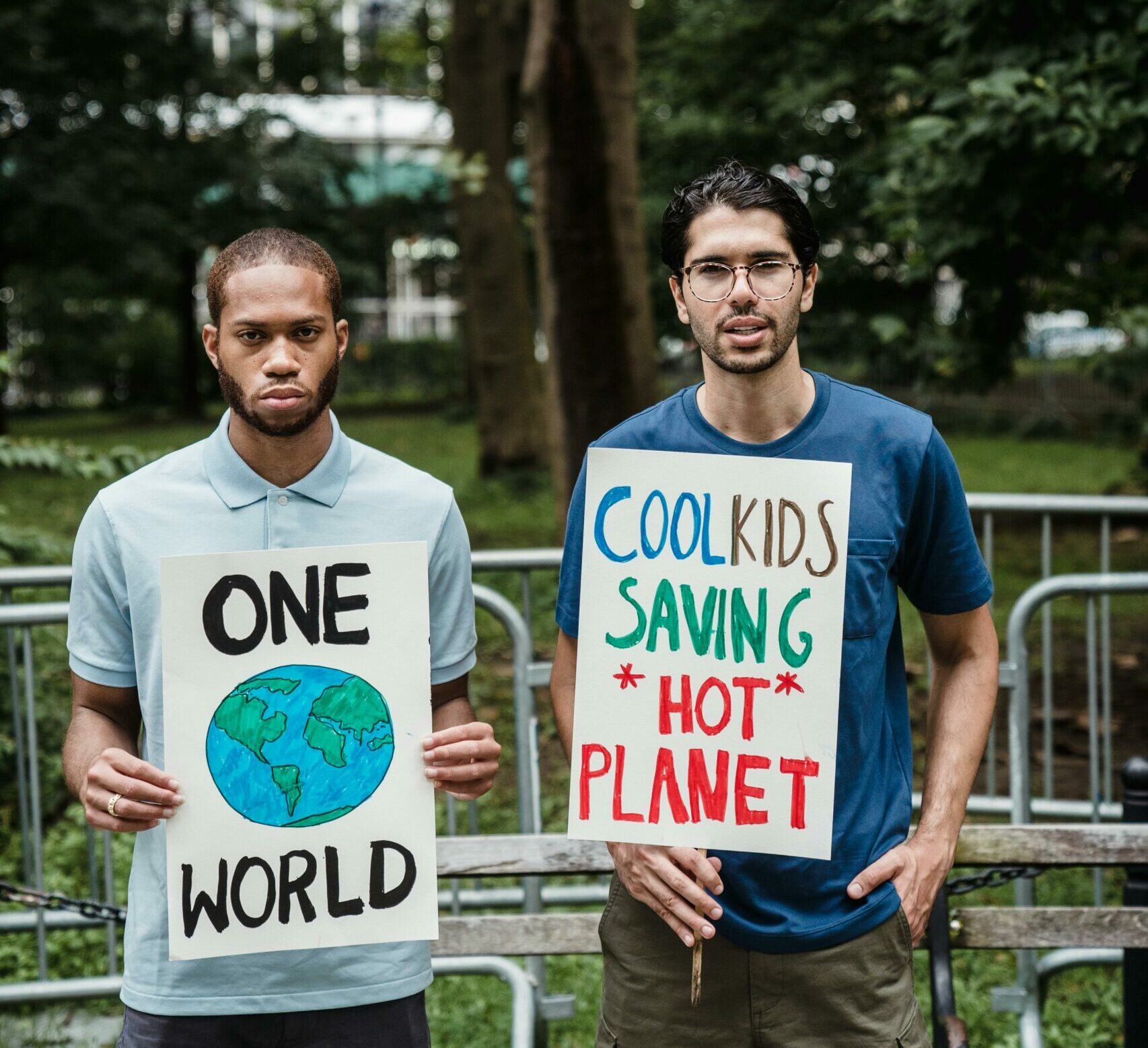 Deux jeunes à un rassemblement tenant des pancartes sur le climat